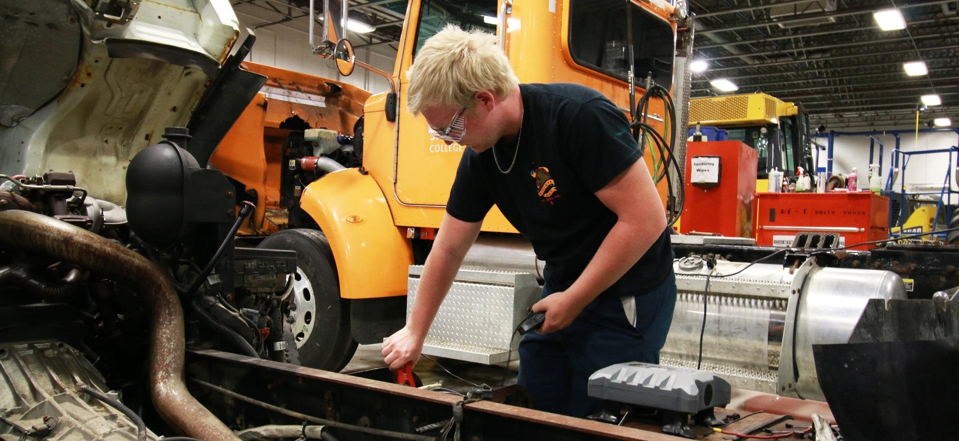 Heavy Equipment student doing repair on a transport truck