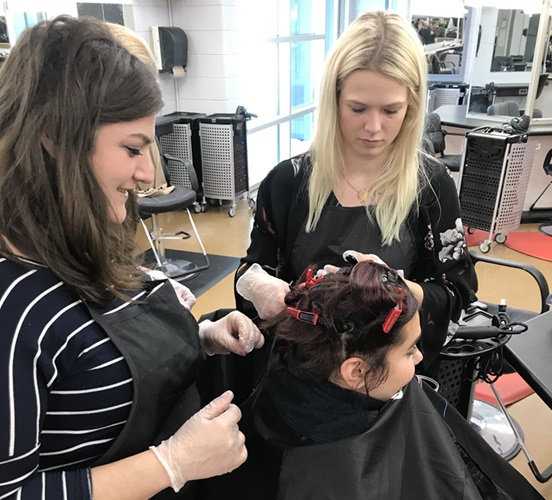 Hairstyling students doing foils on a client