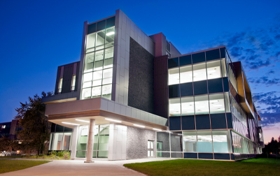 photo of Sault College building at night with lights coming through windows
