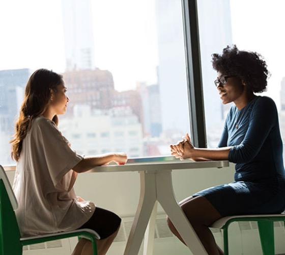 Girl meeting with girl at desk