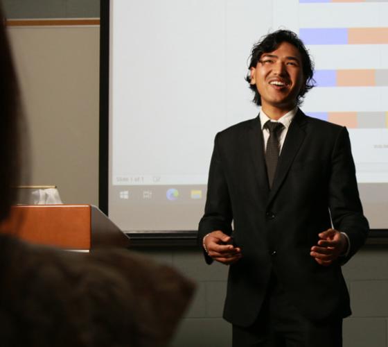 Student in a suit presenting in front of class
