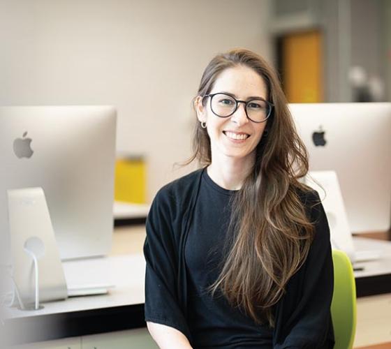 Graphic Design student smiling in Mac computer lab