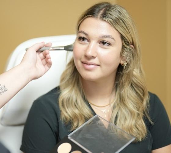 Esthetician student having her makeup done by a classmate