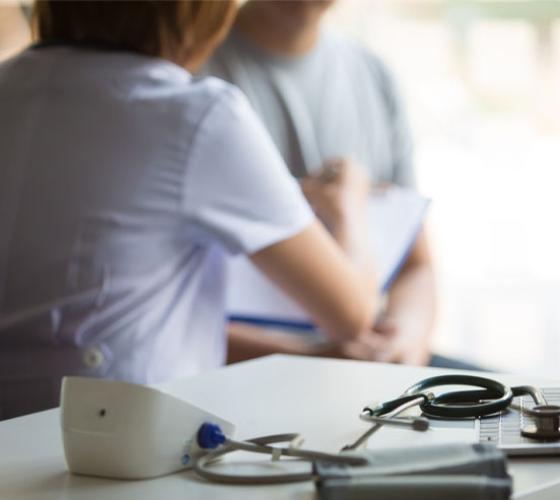 Health centre showing nurse sitting with a person and medical tools on table
