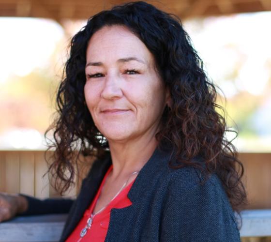 Indigenous counsellor Stephanie looking at camera outside of arbour