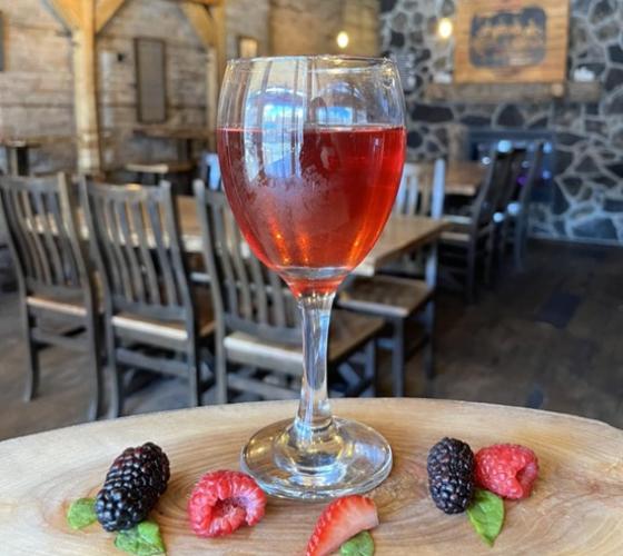 Wine glass filled with fruit wine with restaurant seating behind