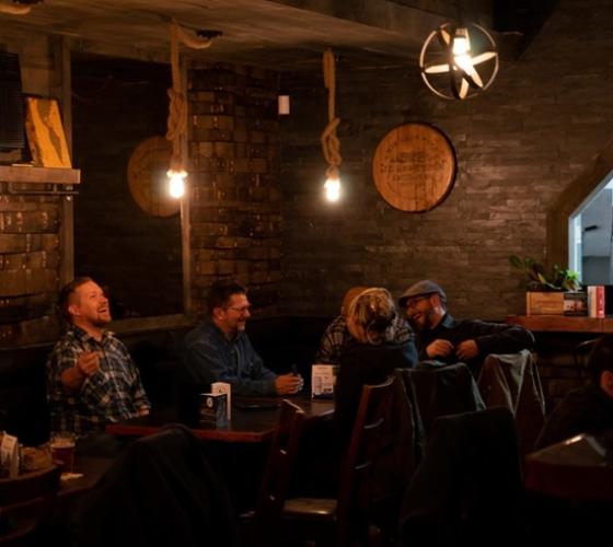 A group sitting at a table in restaurant talking and laughing