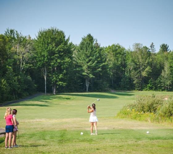 Woman golfing at Silver Creek golf course with two women waiting to the side
