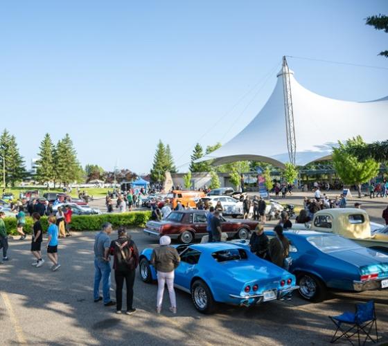 People walking around cars on display around Roberta Bondar Park