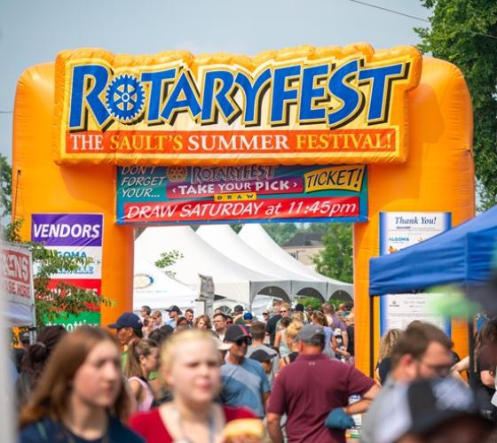 Rotaryfest inflatable arch with a large crowd at the festival grounds