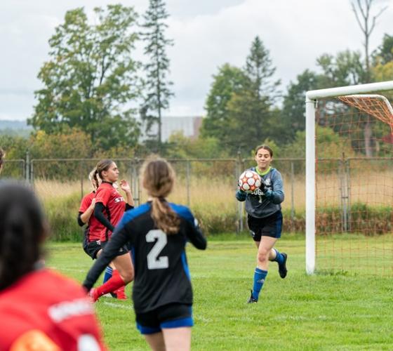 Women's soccer game with goalie catching ball