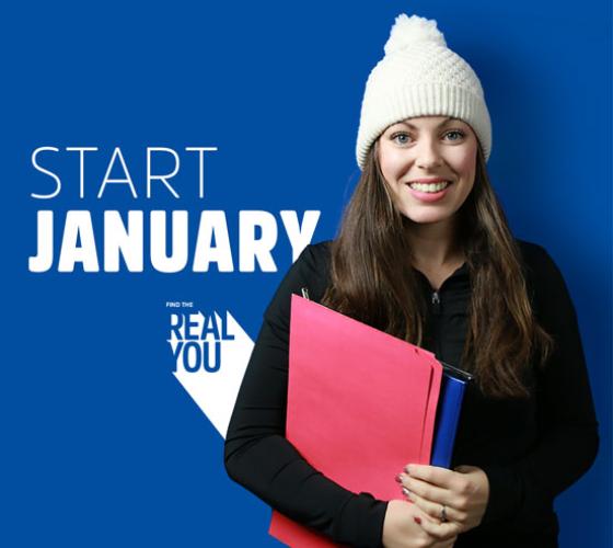 Start January student with toque smiling at camera holding books