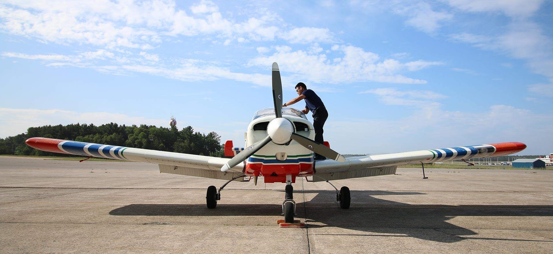 Student preparing Sault College aircraft on runway for flight 