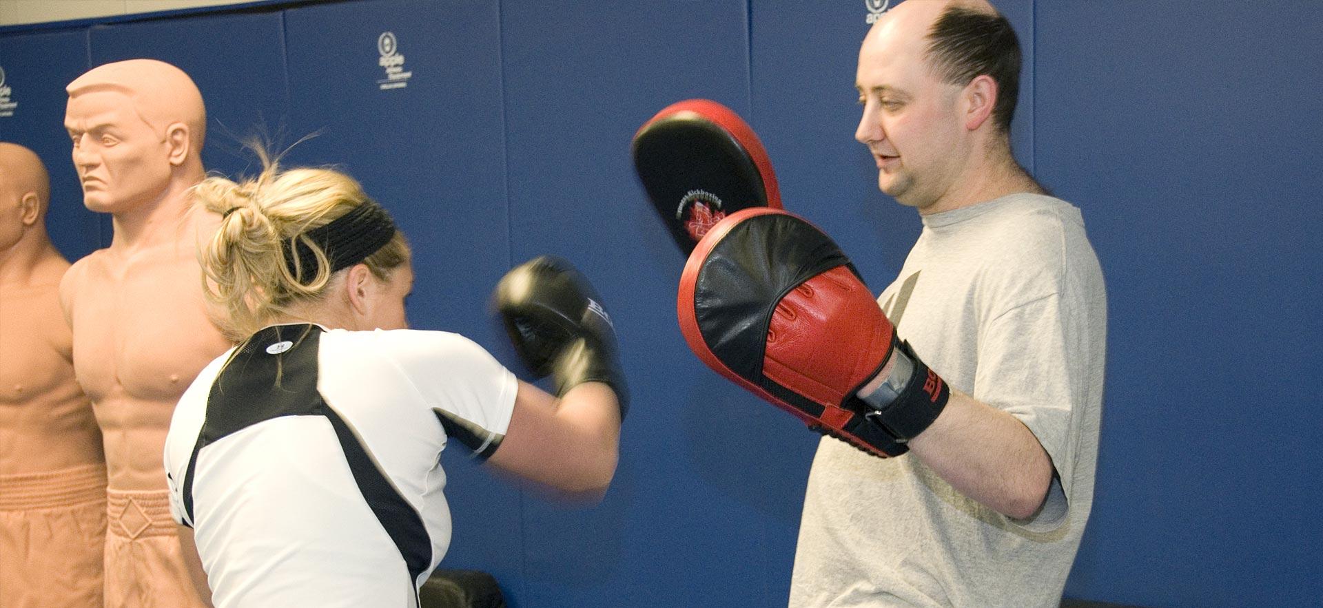 Female Police Foundations student spars with her instructor.