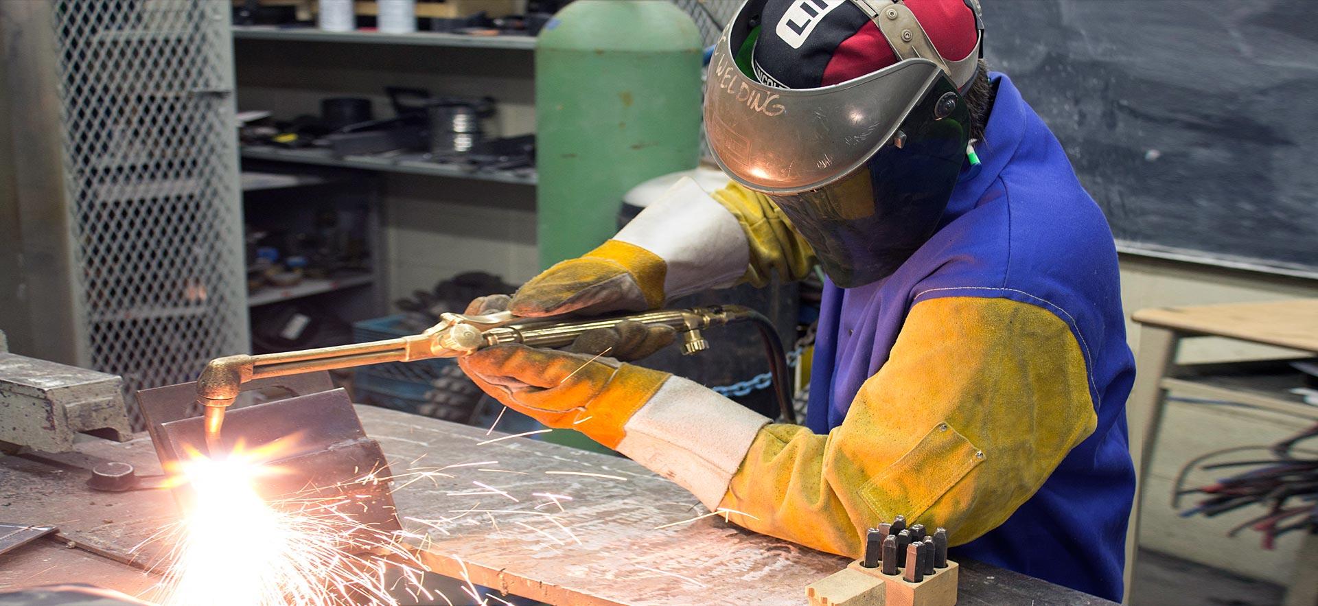 A male Welding Techniques student works on his welding technique.  