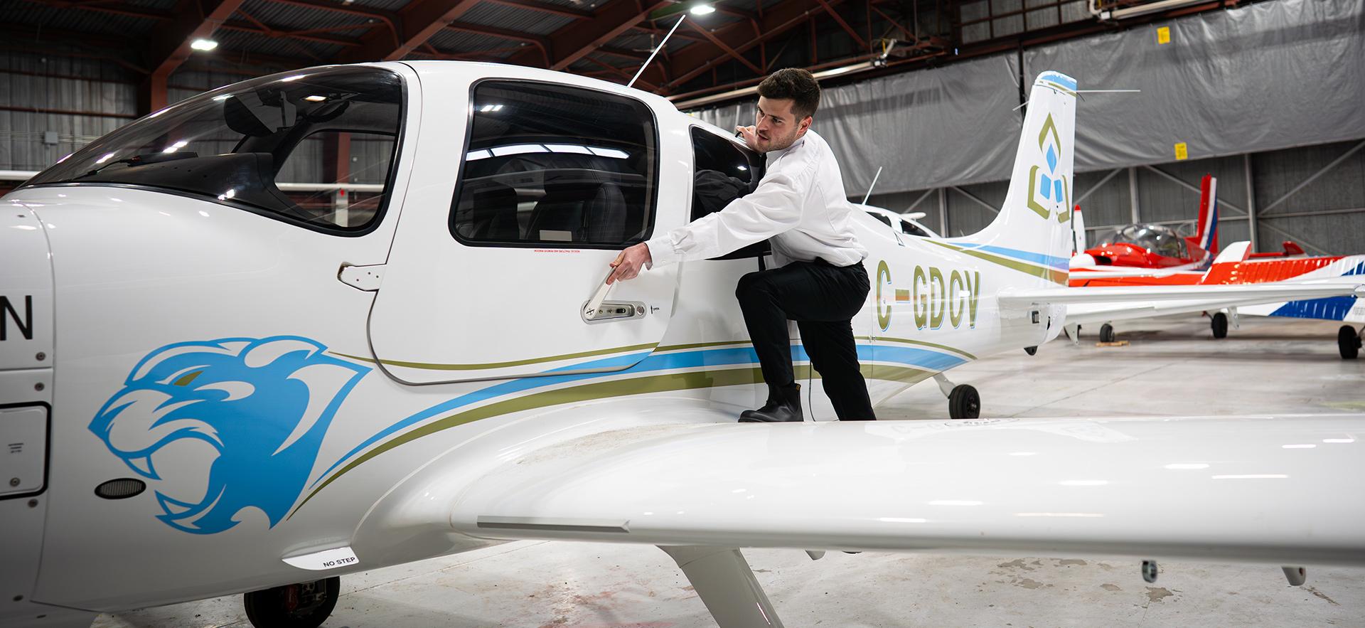 Aviation student about to open door of Cirrus aircraft