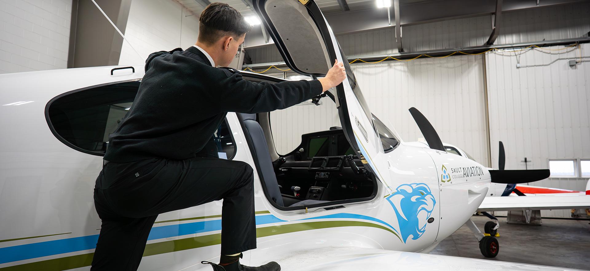 Aviation student opening door of Cirrus aircraft