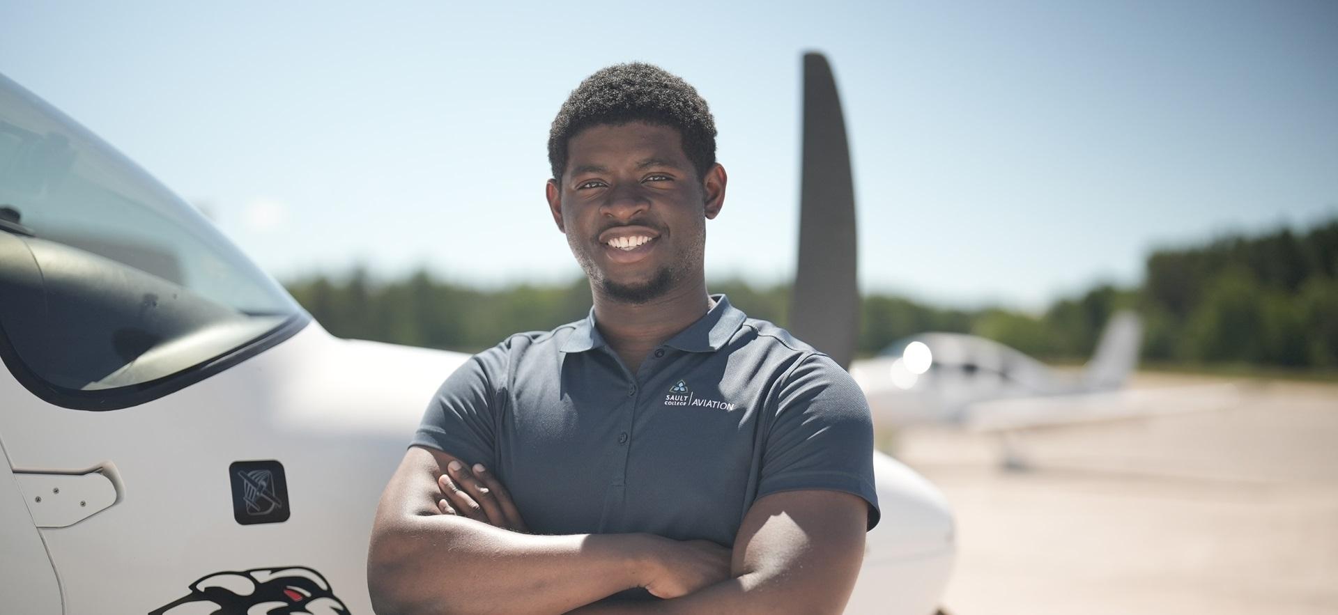 Aviation student posed smiling at camera with Ciruss aircraft in background on apron